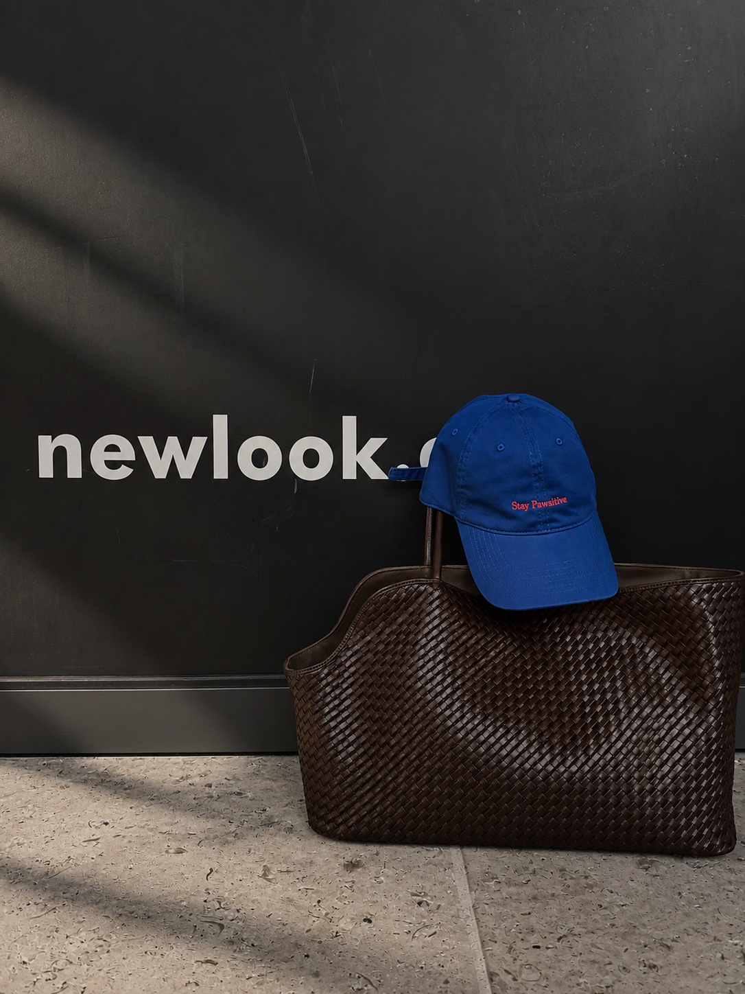A blue Stay Pawsitive cap styled with the Belgravia Woven carrier